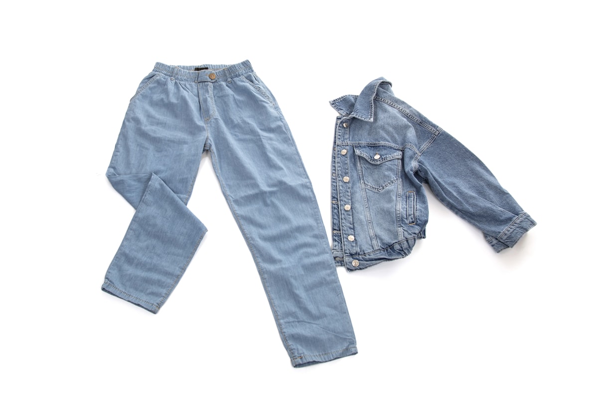 Veste en jean et pantalon posés à plat, fond blanc